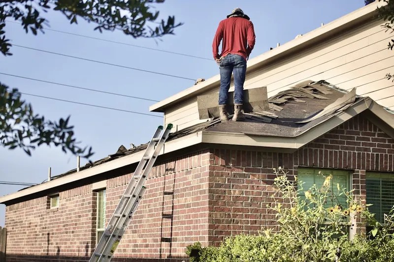 Professional roofer working on a residential roof in Wideview
